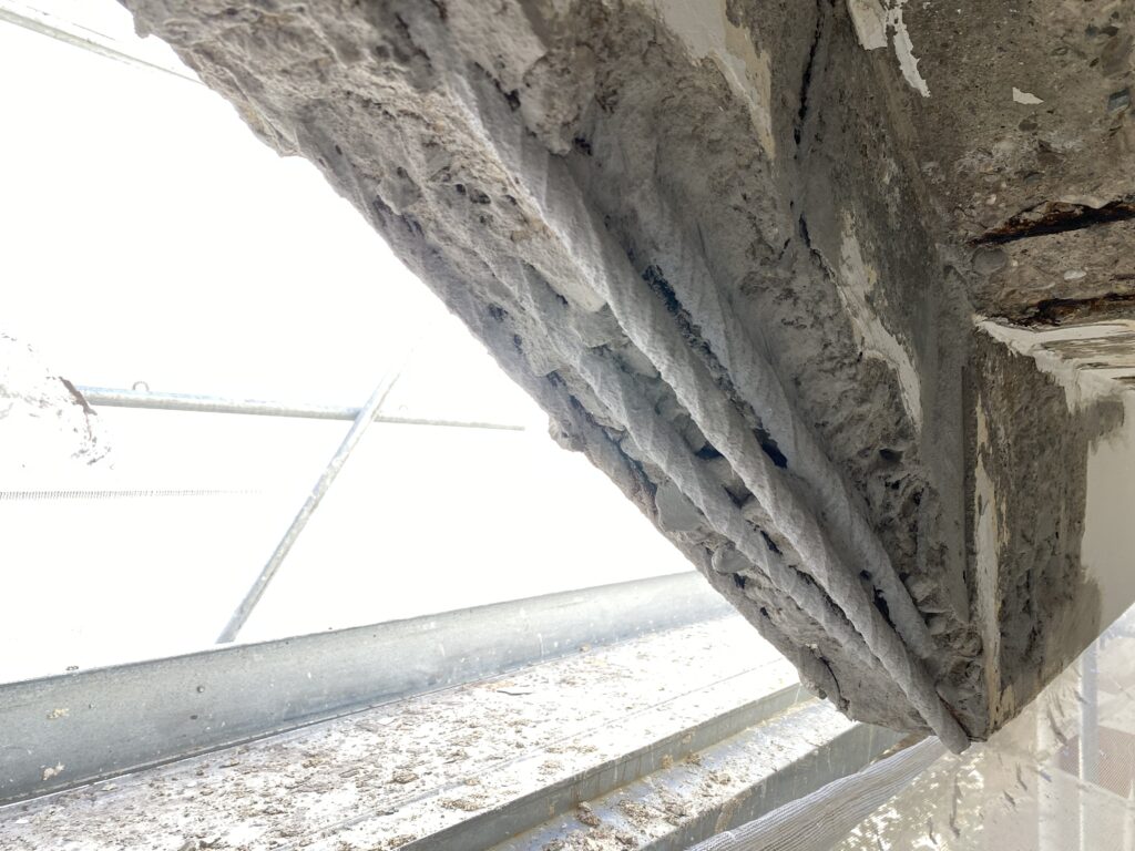 Eclatement de béton sur un mur en retombée